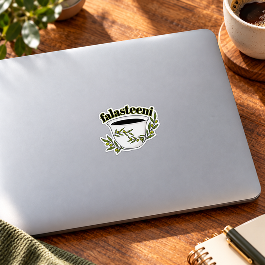 Lifestyle mockup of the Falasteeni coffee cup die-cut sticker on a laptop